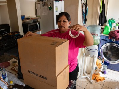María Vela assembles a cardboard box as her family gets ready to move out of their home of nearly 30 years in East Los Angeles on Dec. 17, 2023. Photo by Adriana Heldiz, CalMatters